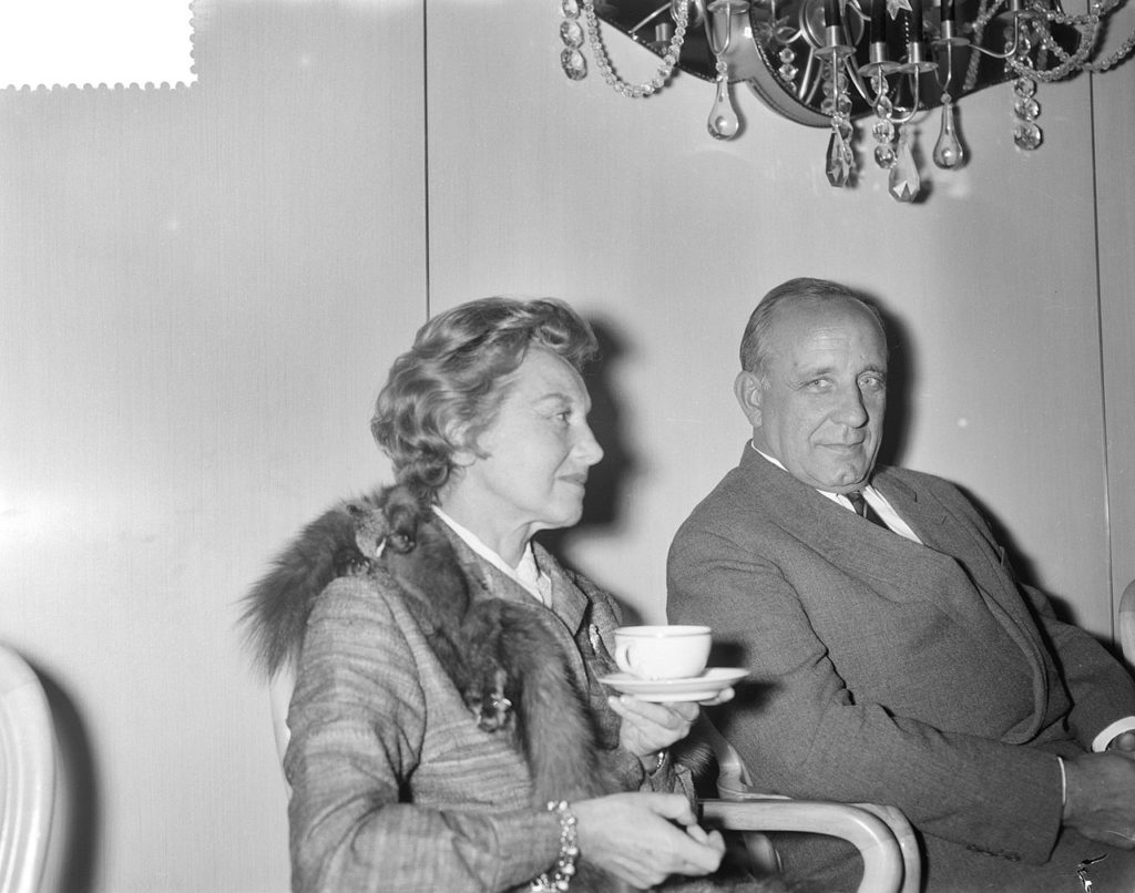 femme et homme lors d'une conférence de presse, années 1950, intérieur élégant