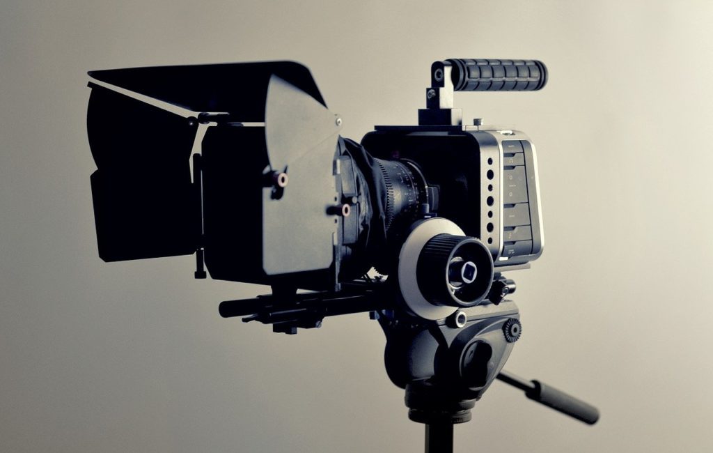 caméra professionnelle équipée de microphone et pare-soleil sur trépied
