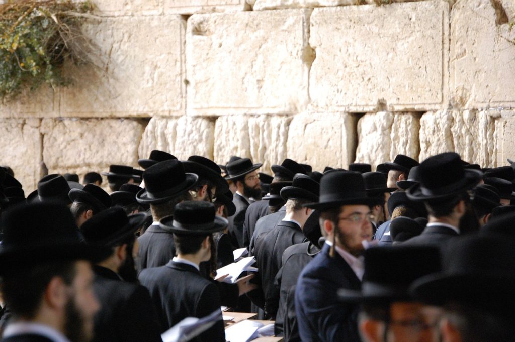 groupe de fidèles en habits traditionnels priant au mur des lamentations à jérusalem