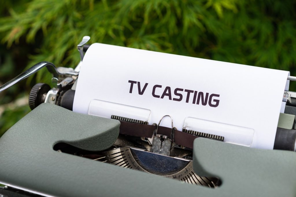machine à écrire avec papier "TV CASTING" sur fond de feuillage vert