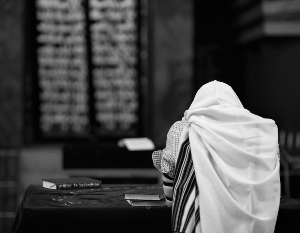 personne enveloppée d'un châle blanc dans une synagogue, photographie noir et blanc