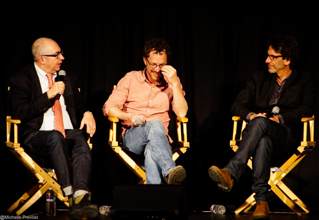trois hommes en discussion sur des chaises metteur en scène lors d'un panel cinéma