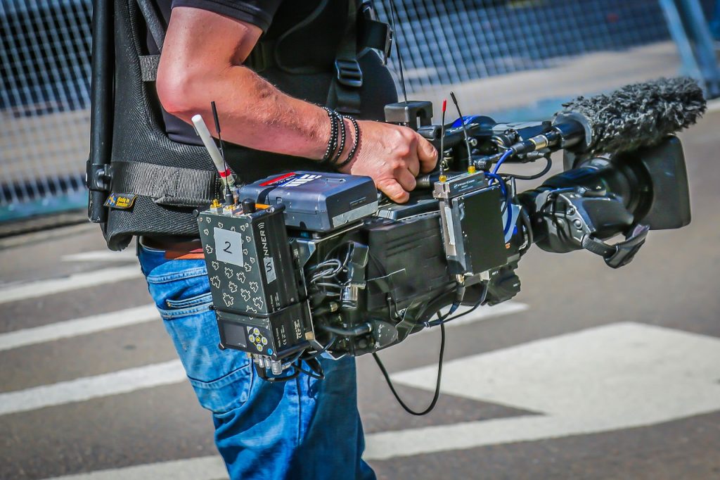 opérateur tenant une caméra professionnelle sur un plateau de tournage cinématographique