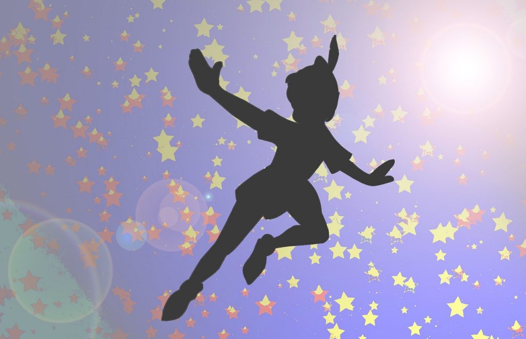 silhouette de peter pan en vol entouré d'étoiles dorées sur fond bleu