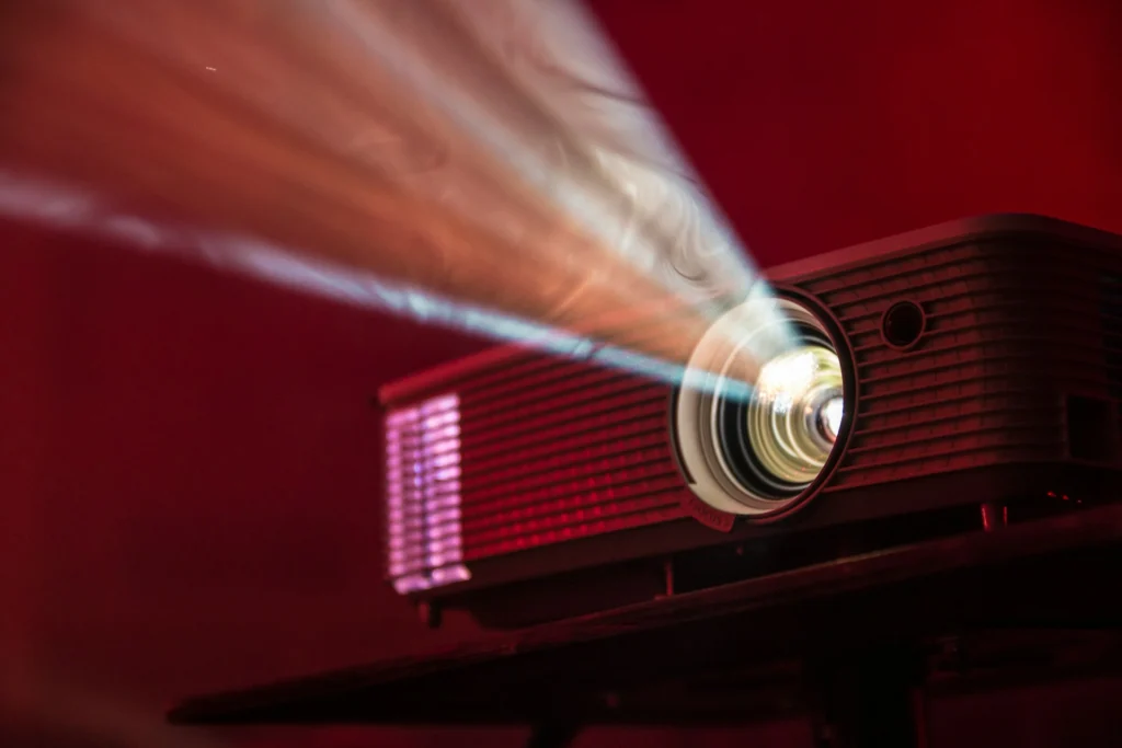 projecteur de cinéma vintage projetant un faisceau lumineux sur fond rouge