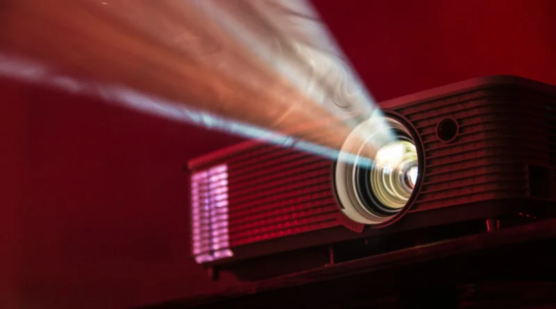 projecteur de cinéma vintage projetant un faisceau lumineux sur fond rouge
