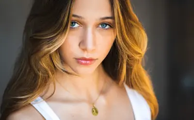 a beautiful young woman with blue eyes posing for a picture