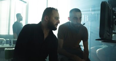 Film crew members collaborating in a Baghdad studio with dramatic lighting.