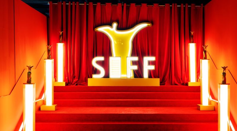 A red carpet entrance with siff logo and golden trophies.